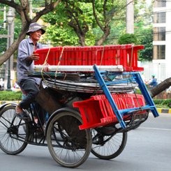 Fahrrad mit kleinen Plastikstühlen beladen